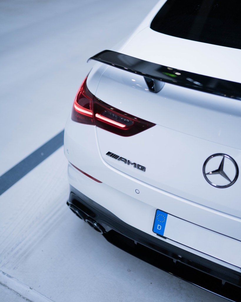 Rear view of a white Mercedes AMG car showcasing its sporty design and taillights.